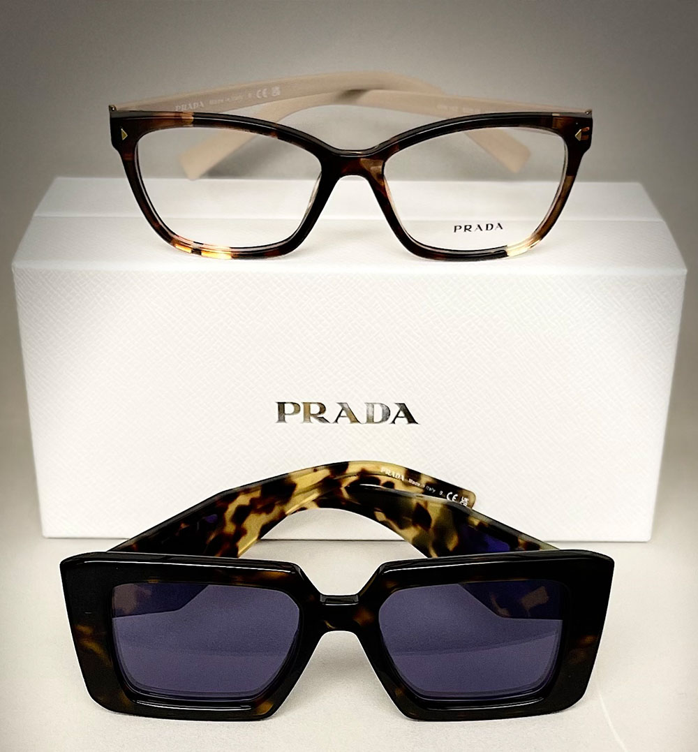 A pair of Prada sunglasses with a leopard print pattern, displayed next to a boxed set of matching eyeglasses.