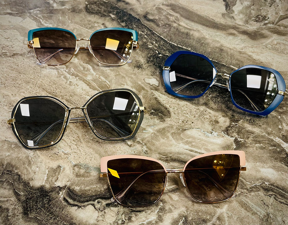 A collection of sunglasses with different frame colors and styles, displayed on a marble surface.